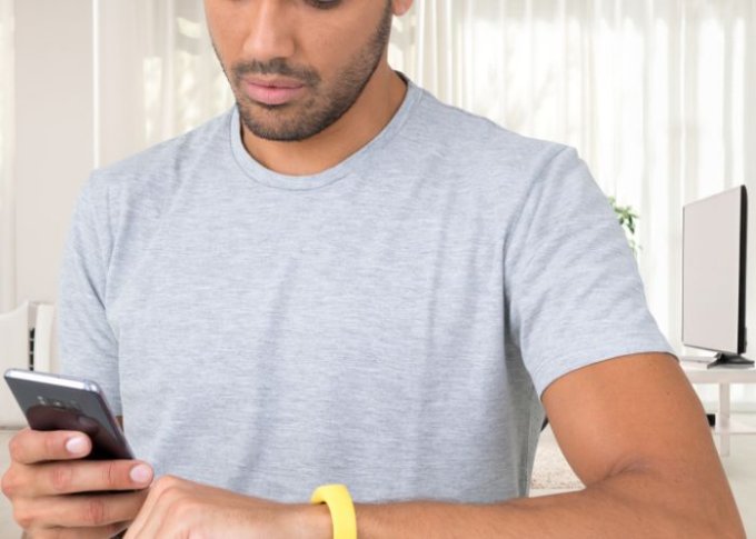 Mężczyzna ma kłopot z uruchomieniem aplikacji do parowania smartwatcha z telefonem