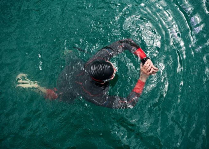 Mężczyzna sprawdza parametry treningowe na smartwatchu do pływania
