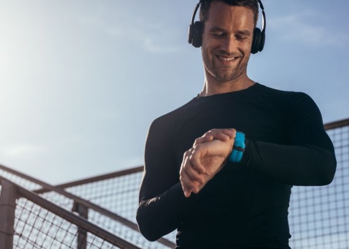 Mężczyzna sprawdza parametry treningowe na swoim smartwatchu do biegania